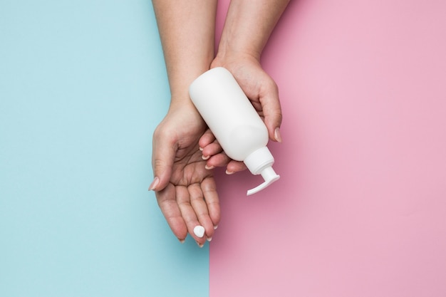 Top view of hands with hydro alcoholic gel bottle