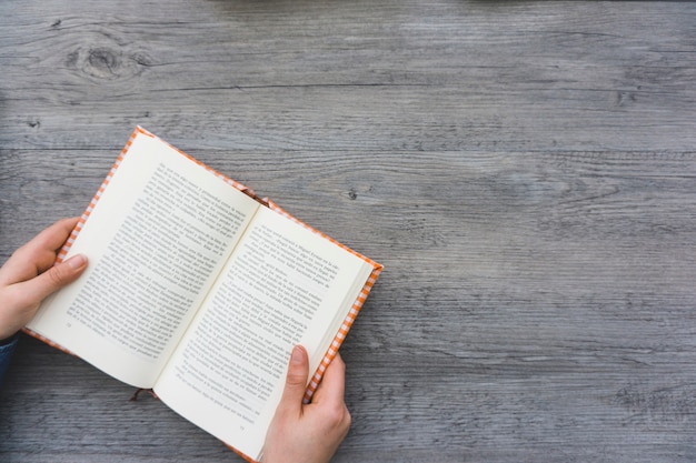 Top view of hands with an open book