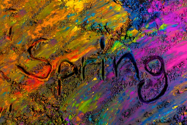 Free photo top view of handwritten spring text on multicolored holi powder