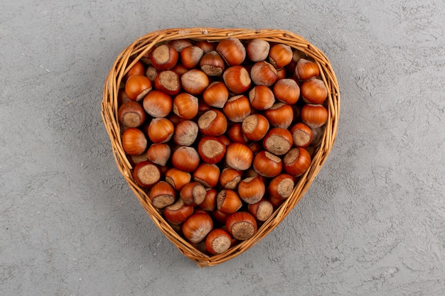 top view hazelnuts inside basket on the grey desk