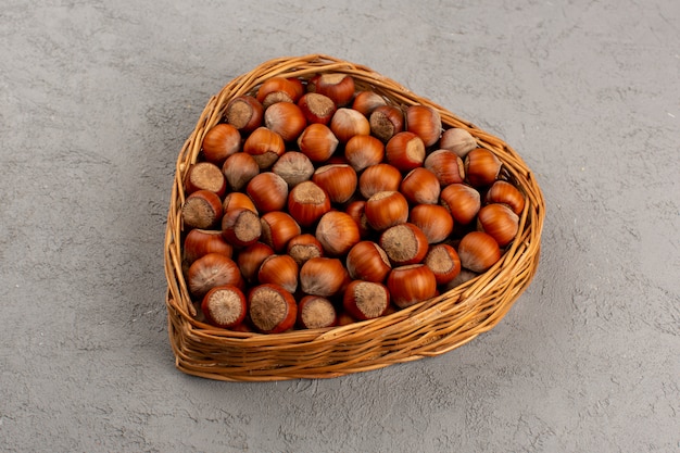 top view hazelnuts whole inside basket on the grey background