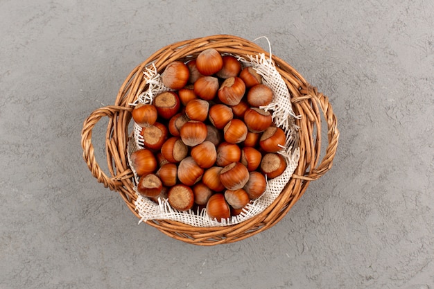 top view hazelnuts whole inside basket on the grey floor