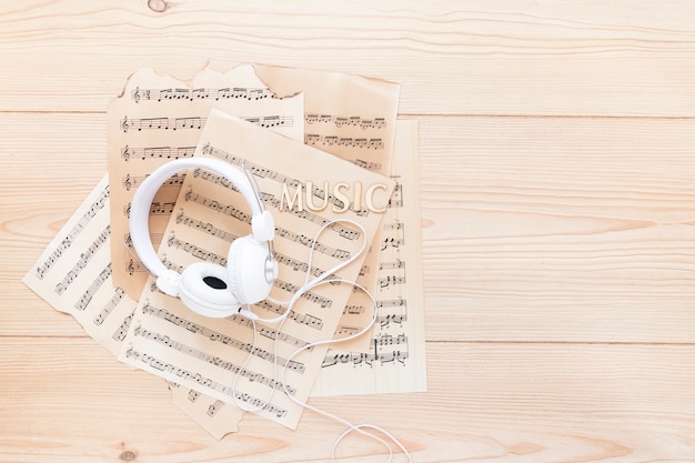 Free photo top view headset with music sheets