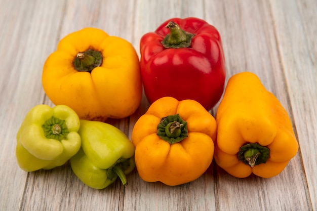 Top view of healthy colorful bell peppers isolated on a grey wooden wall