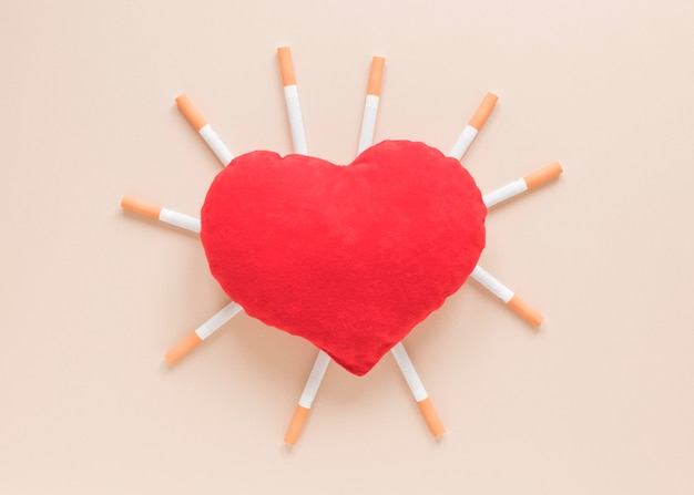 Top view heart surrounded by cigarettes