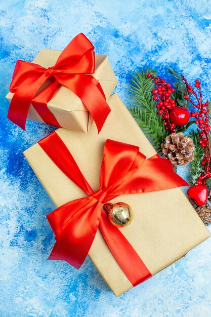 Top view holiday gifts tied with red ribbon xmas ornaments on blue white table