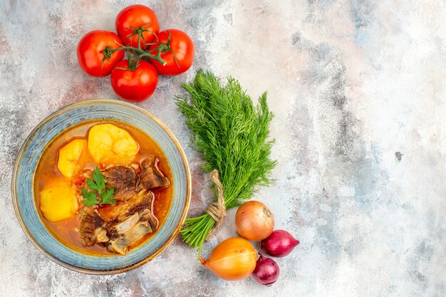 Top view homemade bozbash soup a bunch of dill tomatoes onions on nude background free space