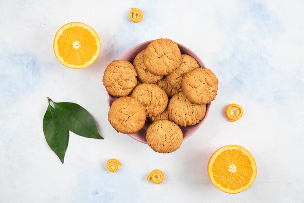 Top view of Homemade cookies on wooden board and fresh juicy oranges.