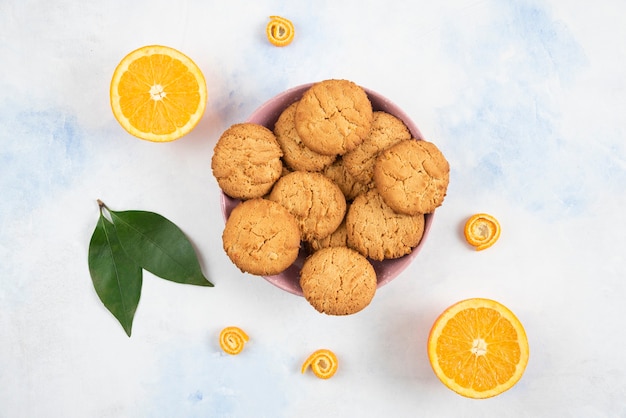 Top view of Homemade cookies on wooden board and fresh juicy oranges.