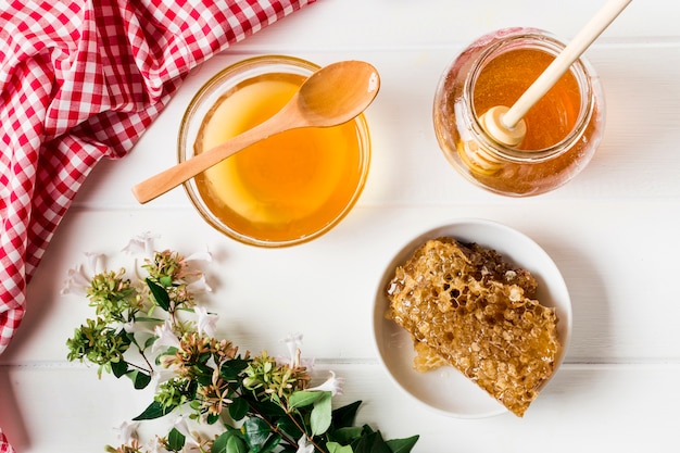 Free photo top view honey containers with honeycomb