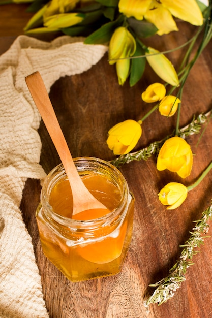 Free photo top view honey jar with flowers