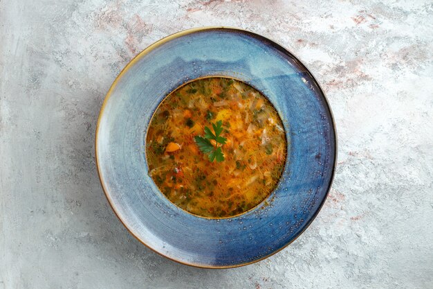 Top view hot vegetable soup inside plate on white space