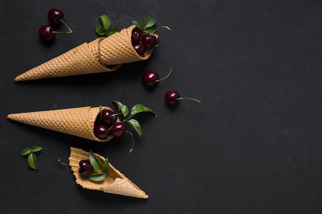 Free Photo top view ice cream cones with cherries