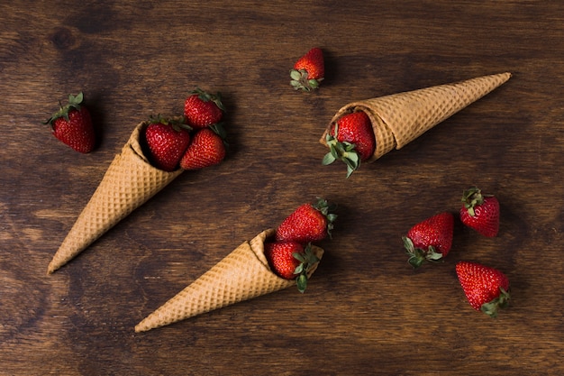 Free Photo top view ice cream cones with strawberries