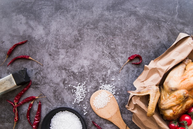 Top view of ingredients and baked chicken over concrete background