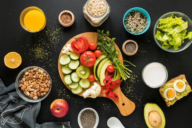 Free photo top view of ingredients; dryfruits and vegetables on black background