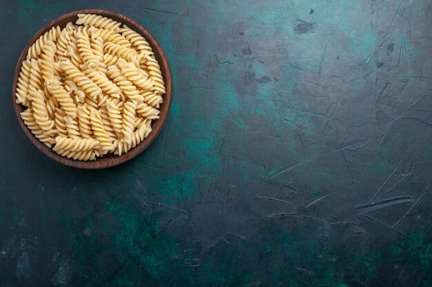 Free Photo top view italian pasta delicious looking inside brown pot on dark blue desk italian pasta food meal dinner cooking kitchen dough