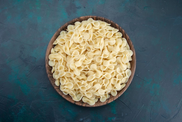 Top view italian pasta inside plate on dark-blue