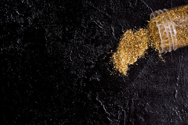 Top view jar with golden glitter on slate background