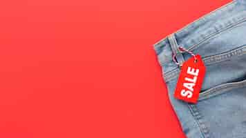 Free photo top view jeans with sale label on red background