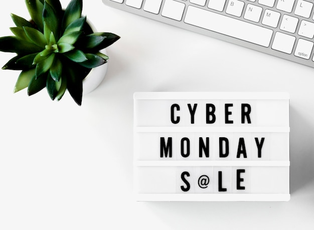 Free Photo top view of keyboard with plant and cyber monday light box