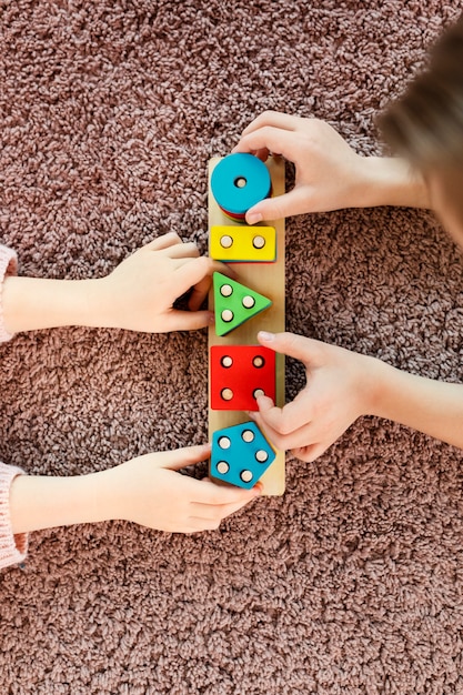 Top view kids playing with wooden toy