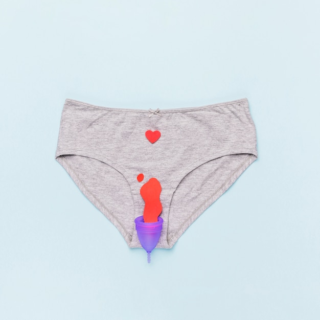 Free photo top view knickers with menstrual cup and paper stain