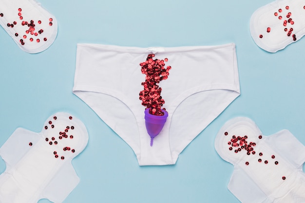 Free photo top view knickers with red sequins and menstrual cup