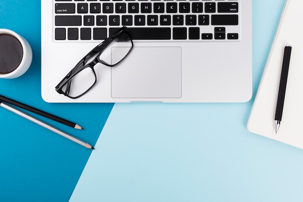 Top view of laptop and glasses with copy space