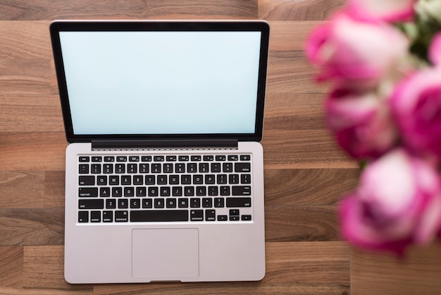 Free Photo top view of laptop with blurred flowers