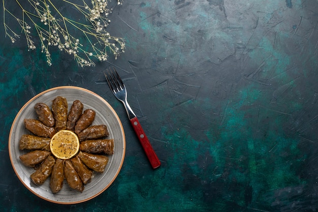 Free Photo top view leaf dolma delicious eastern meat meal rolled inside green leaves on the blue desk meat food dinner dish vegetables health