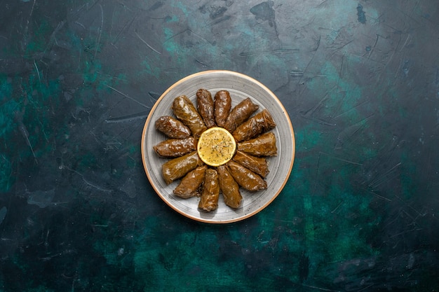 Free Photo top view leaf dolma delicious eastern meat meal rolled inside green leaves on dark blue desk meat meal food dinner vegetables health calorie