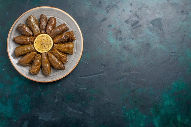 Free Photo top view leaf dolma delicious eastern meat meal rolled inside green leaves on the dark-blue desk meat meal food dinner vegetables health calorie