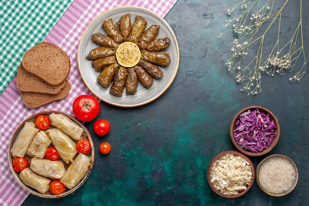 Top view leaf dolma eastern meat meal rolled inside green leaves with bread and cabbage dolma on dark-blue desk meat dinner dish east meal