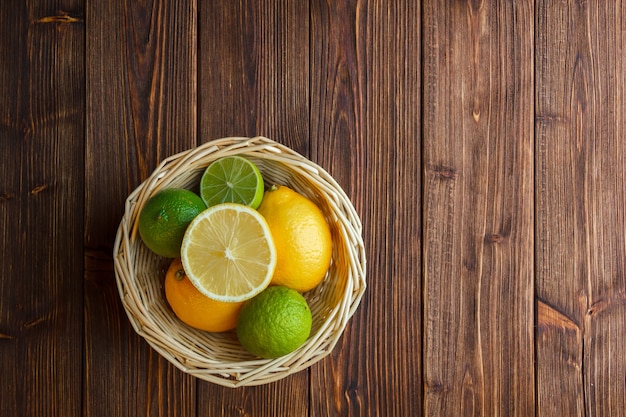 Top view lemons in basket on wooden background.