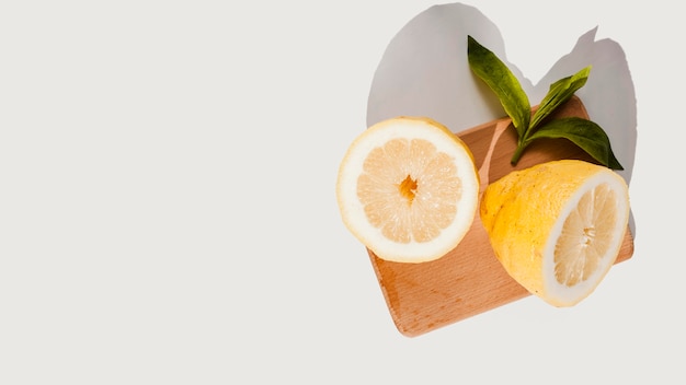 Free photo top view lemons on wooden board