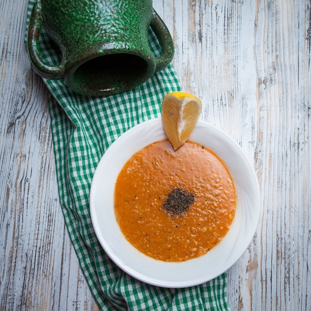 Top view lentil soup with lemon and jug in food board