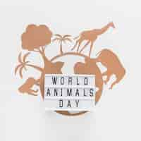 Free photo top view of light box with paper planet and animals for animal day