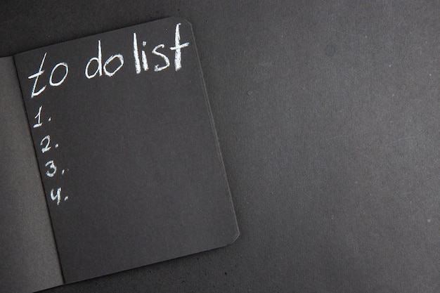 Free Photo top view to do list written on black notebook on black table free space