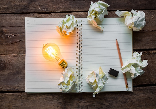 Free Photo top view of lit light bulb next to paper balls