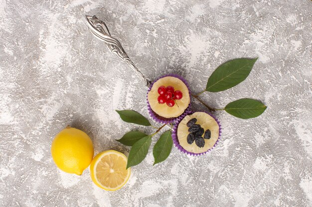 Top view little chocolate brownies with cranberries and lemons on the light background cake biscuit sweet bake dough