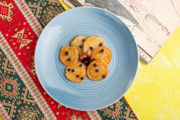 Top view little cookie pastries inside blue plate on yellow table, bake sweet tea pastry