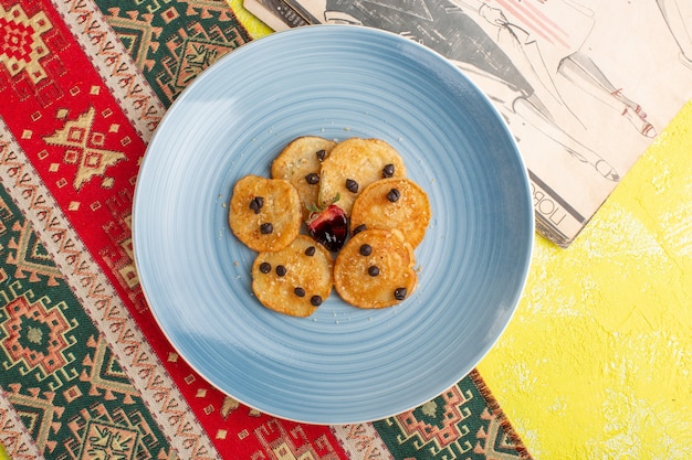 Top view little cookie pastries inside blue plate on yellow table, bake sweet tea pastry