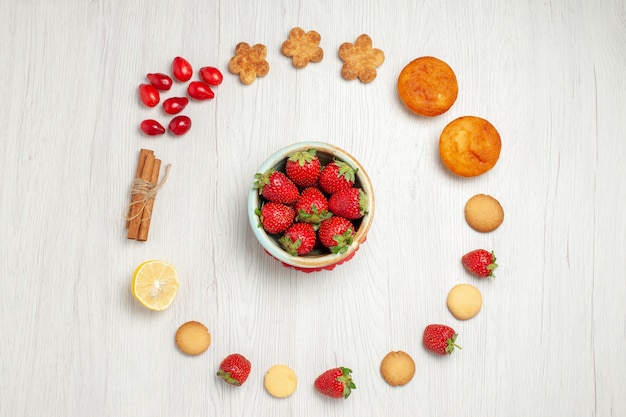 Top view little cookies with fresh fruits on white desk