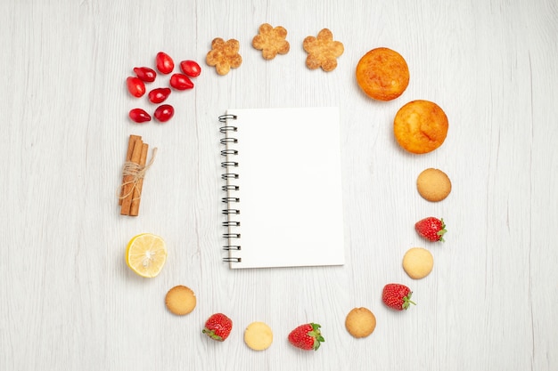 Top view little cookies with fruits on a white desk