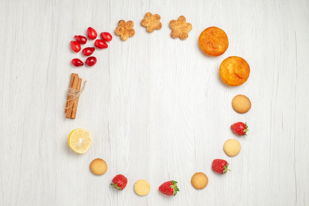 Top view little cookies with fruits on white desk