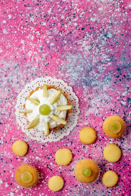 Top view little delicious cake with sliced fruits cookies on the colored table cake sweet sugar color