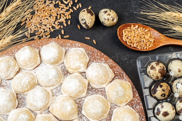 Top view little dough pieces with flour on dark background color pie cake hotcake dough dumpling bun meat