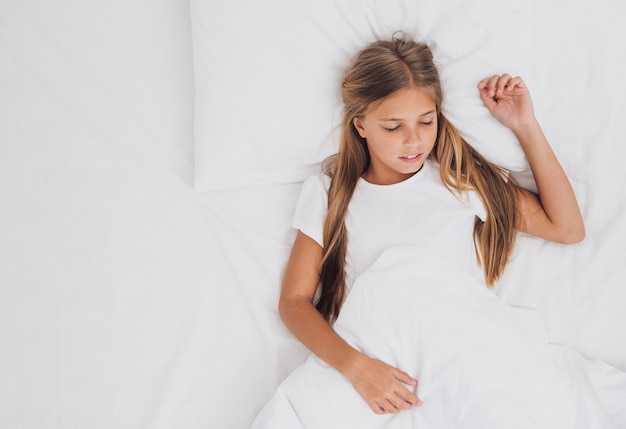 Free photo top view little girl sleeping with copy space