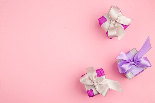 Top view of little presents on a pink surface